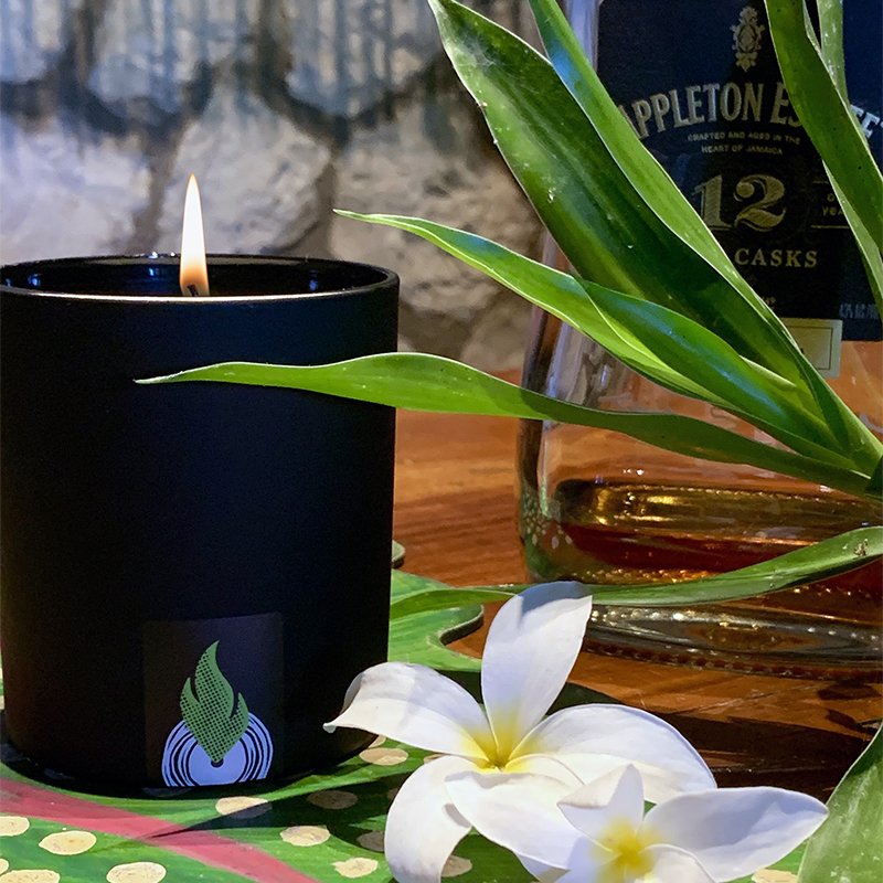 Seven Mile candle burning in a vaulted Jamaican home, surrounded by tropical florals and Appleton rum. A scent throw that takes over the room... effortlessly.